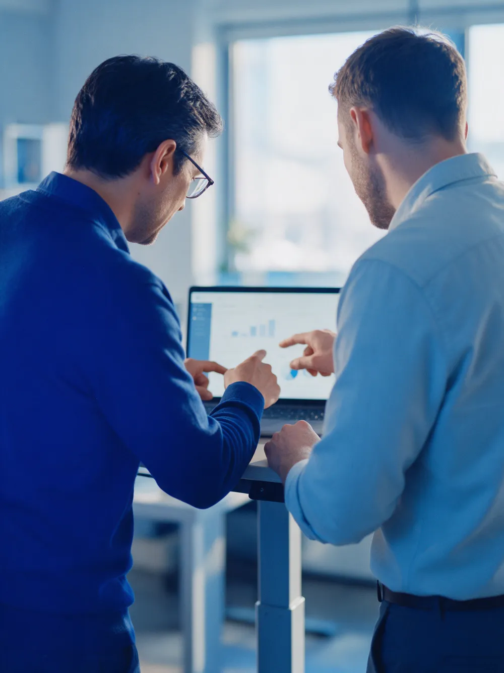 Service lead and client engineer reviewing a service report on a laptop