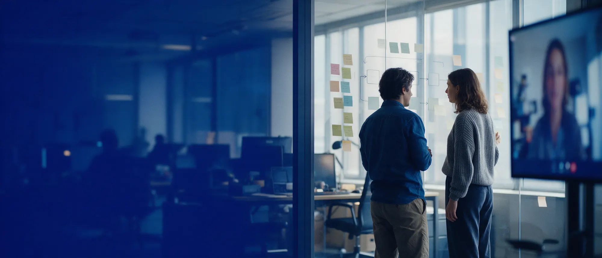 Onshore and offshore team members mapping a test process on a glass wall during a video call