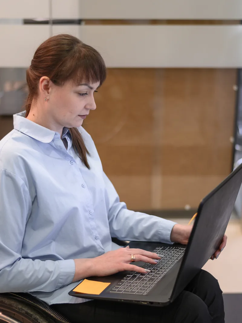 Wheelchair user completing a task on a laptop