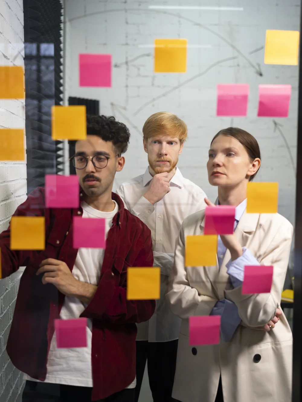 Team mapping current and future state with sticky notes on a glass wall