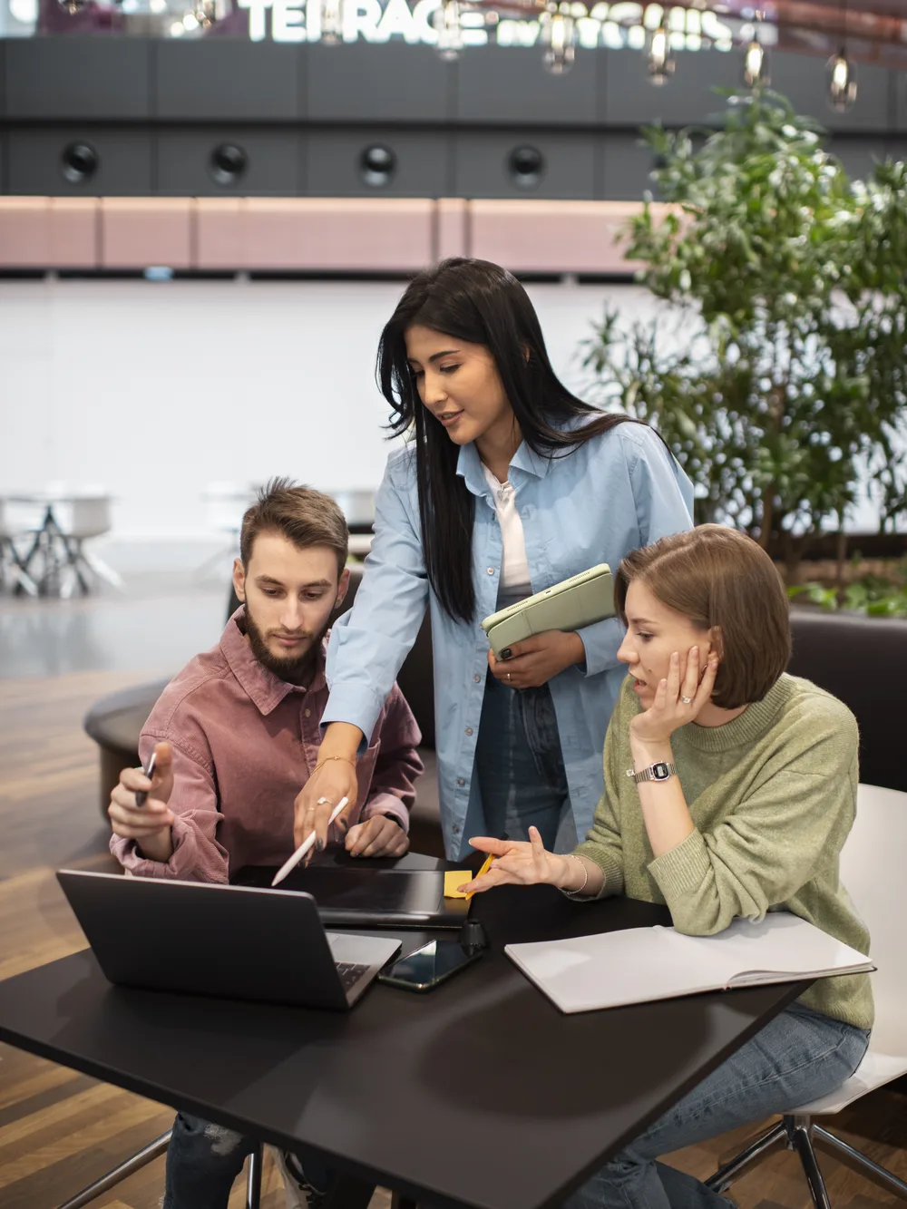 Small team working together at a laptop in a bright open office