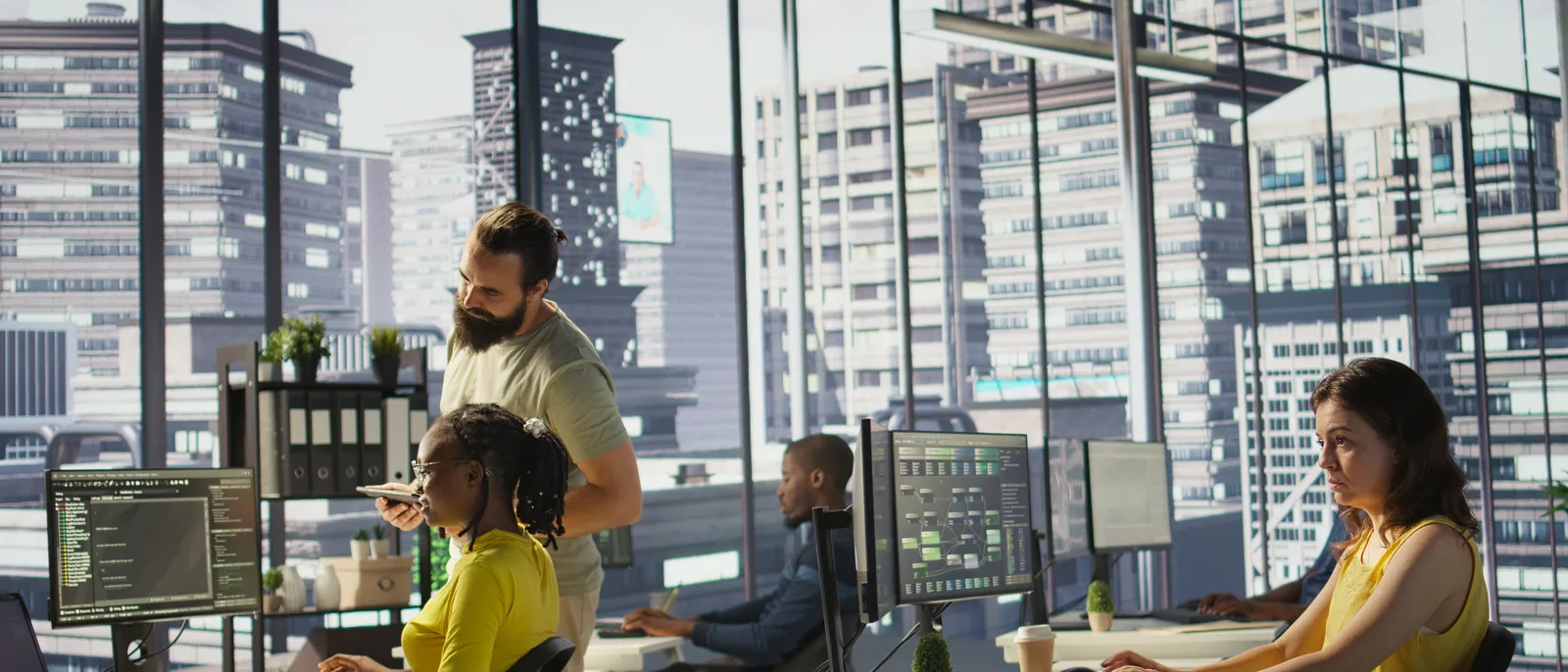 Engineering team at multi-screen workstations in a city office