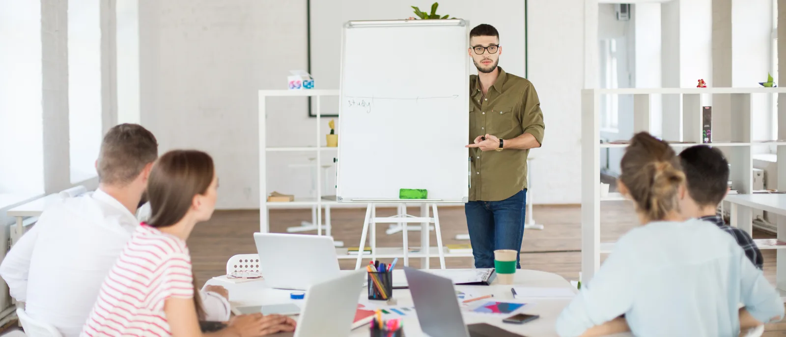 Team gathered around a whiteboard in a bright office