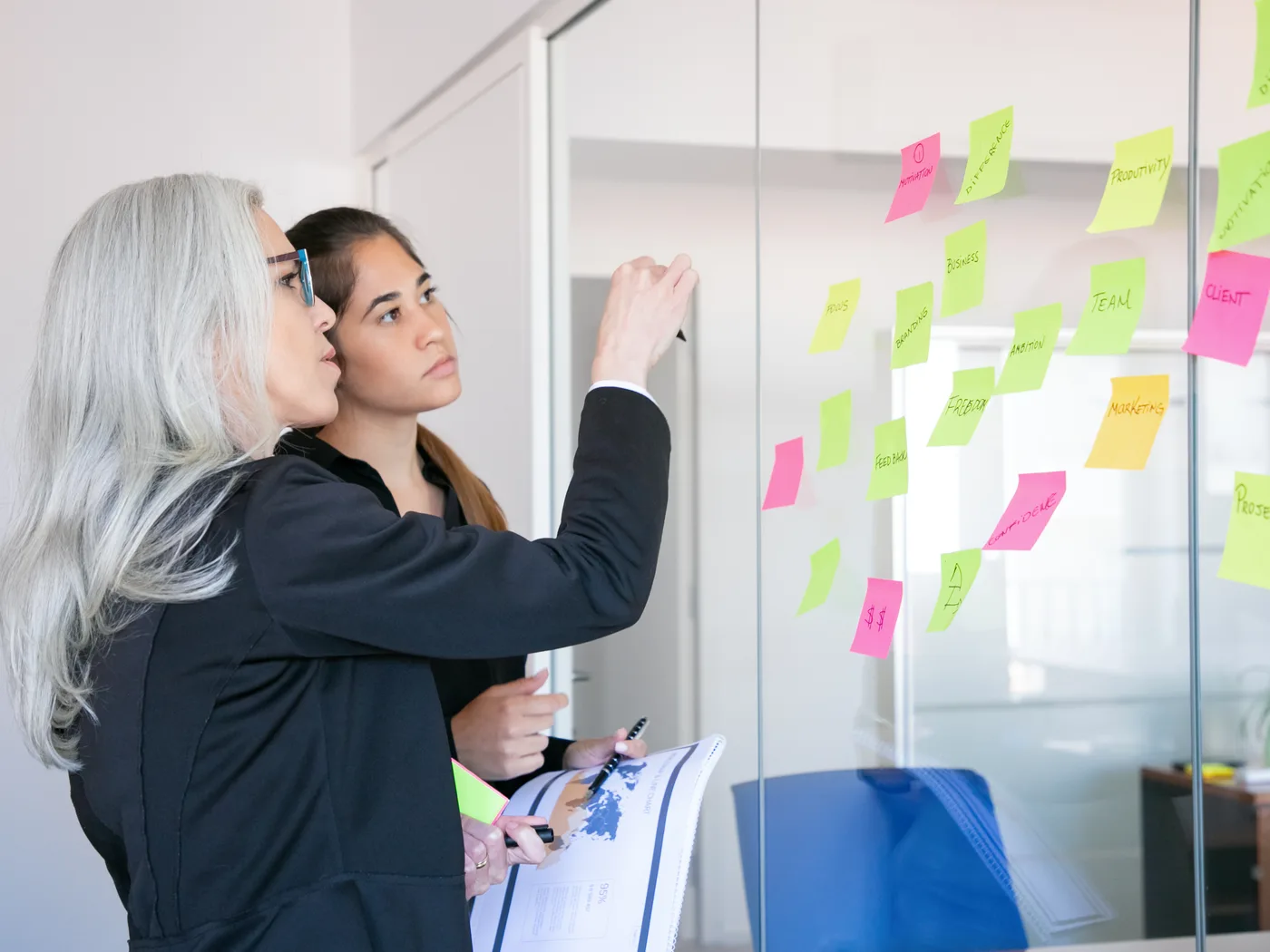Two businesswomen mapping a process on sticky notes