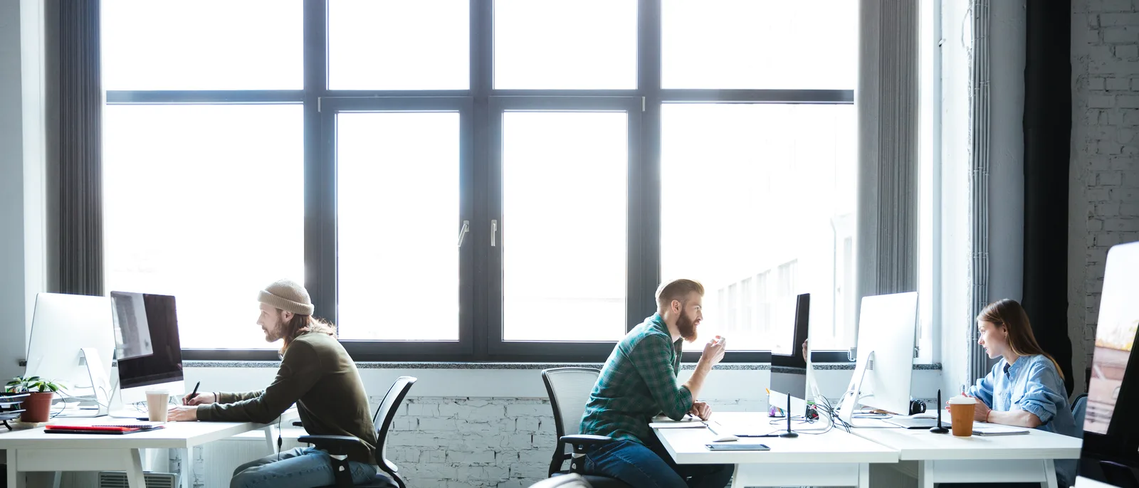 Wide loft office with colleagues working at computers
