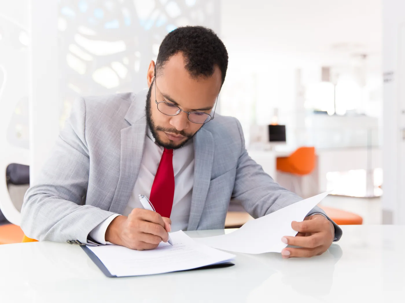 Auditor in glasses checking and signing compliance documents