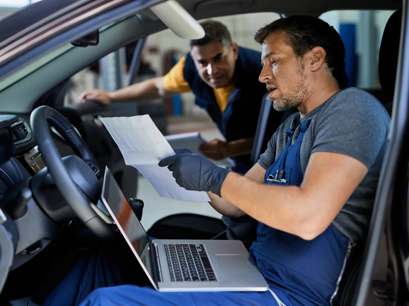 Engineers analysing vehicle test data on a laptop