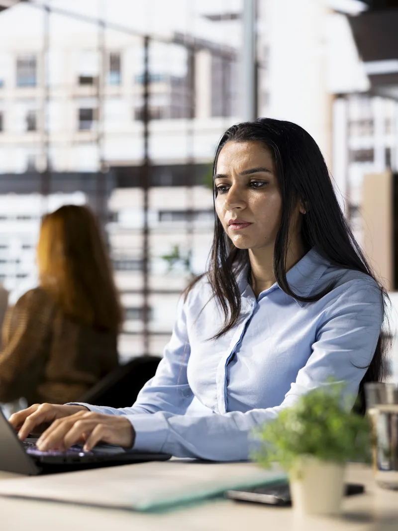 Banking analyst working on laptop in city office