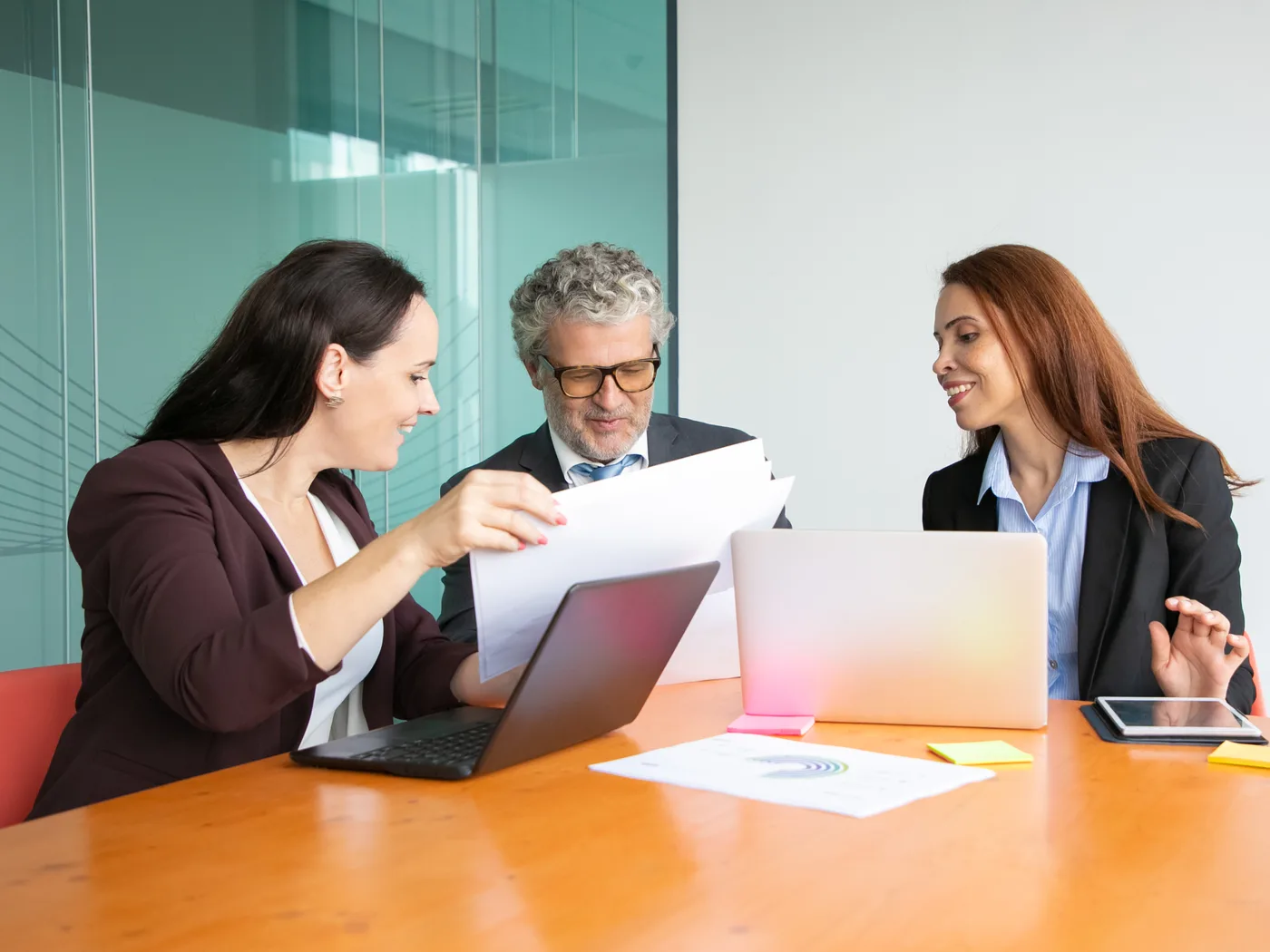 Manager reviewing reports with two colleagues