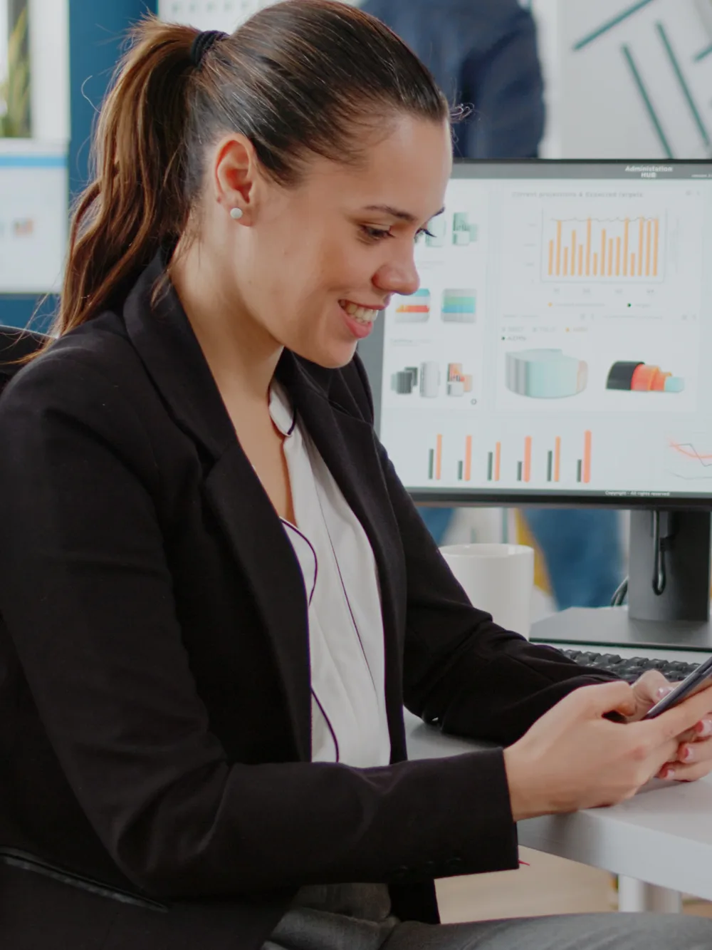 Businesswoman checking her phone beside office charts