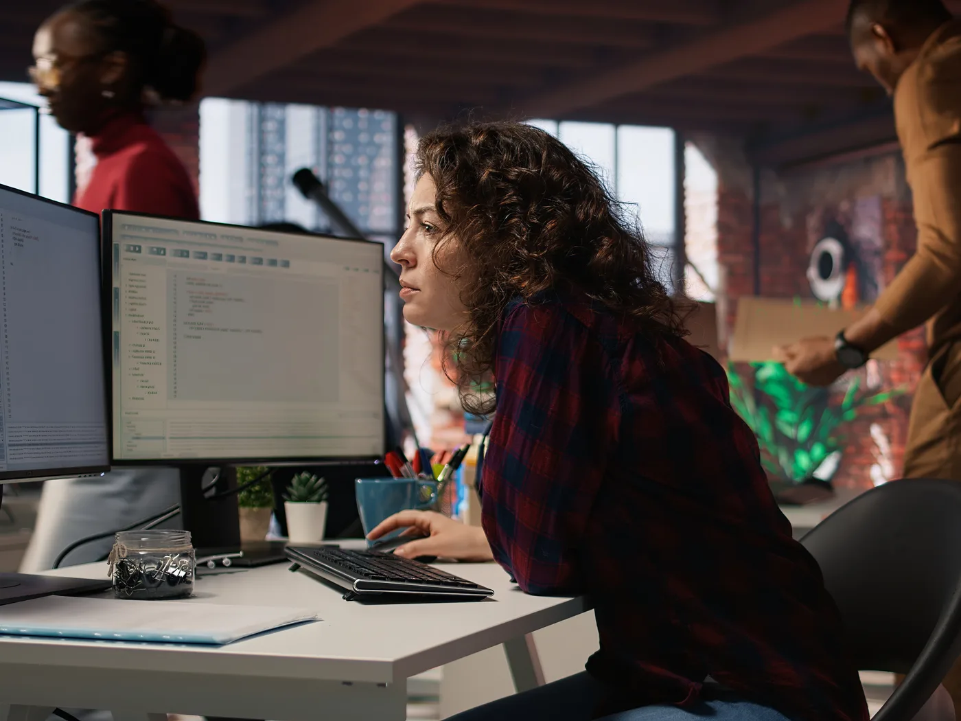 Security specialist working across two monitors in an office