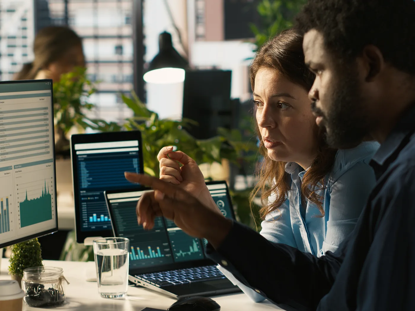 Two colleagues comparing data on a monitor
