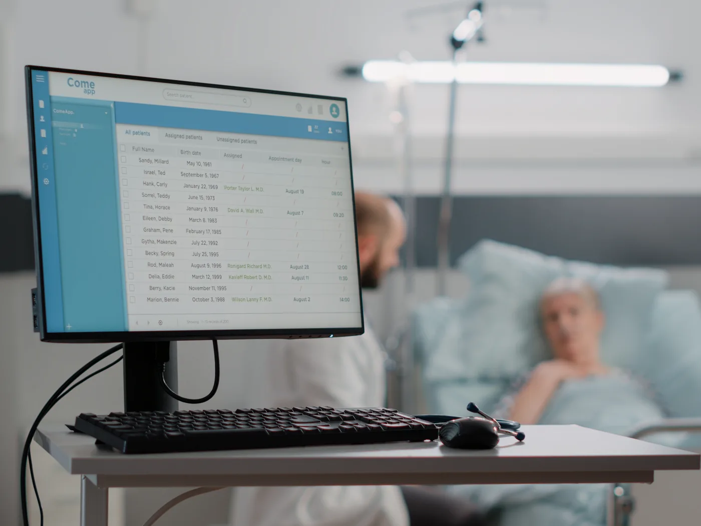 Patient records screen beside a hospital ward bed