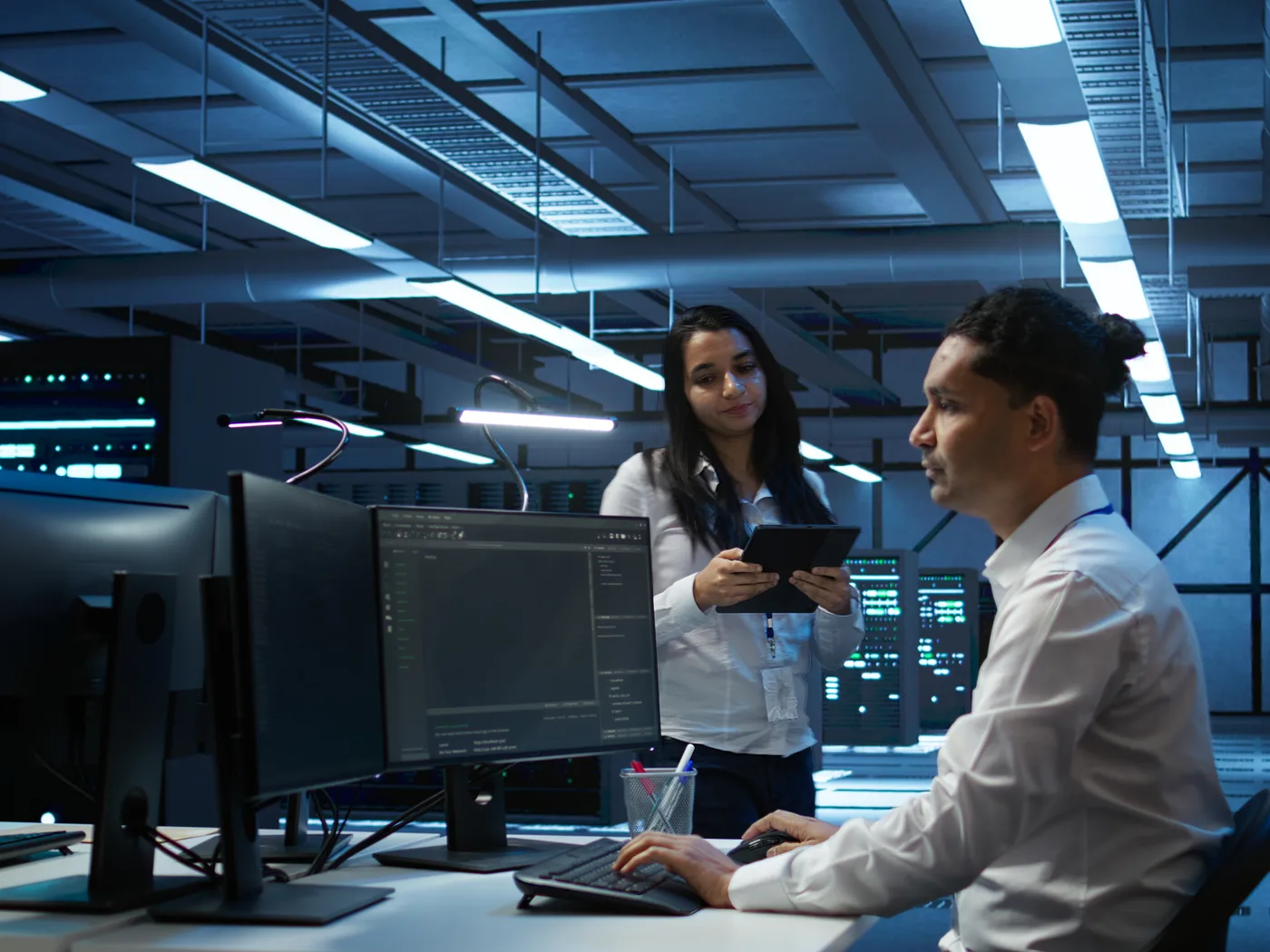 Engineers working at monitors in a data centre