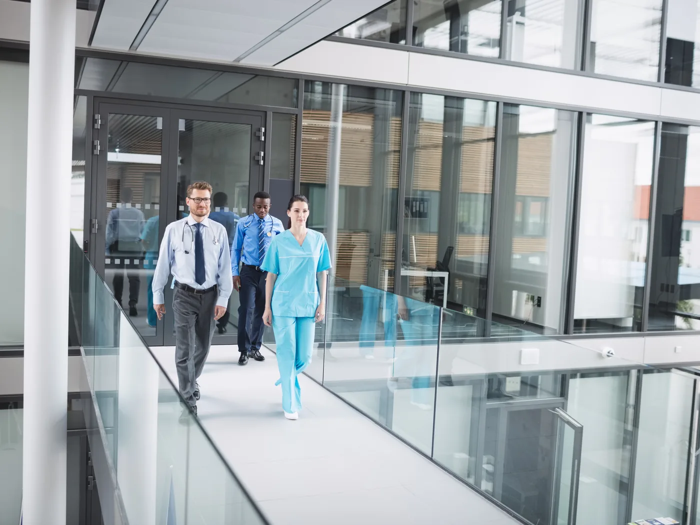 Clinicians walking along a modern hospital corridor
