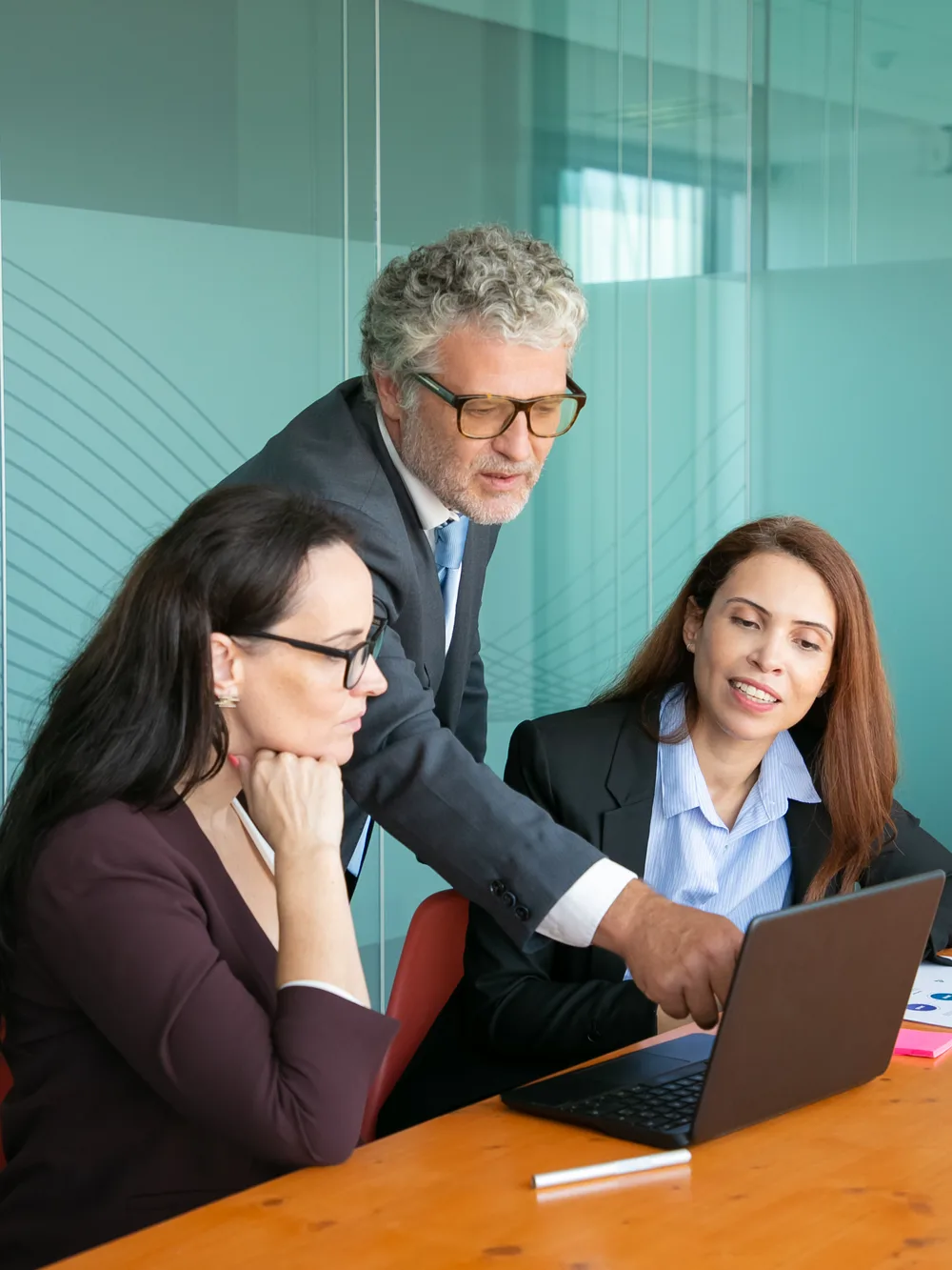 Senior consultant guiding colleagues at a laptop