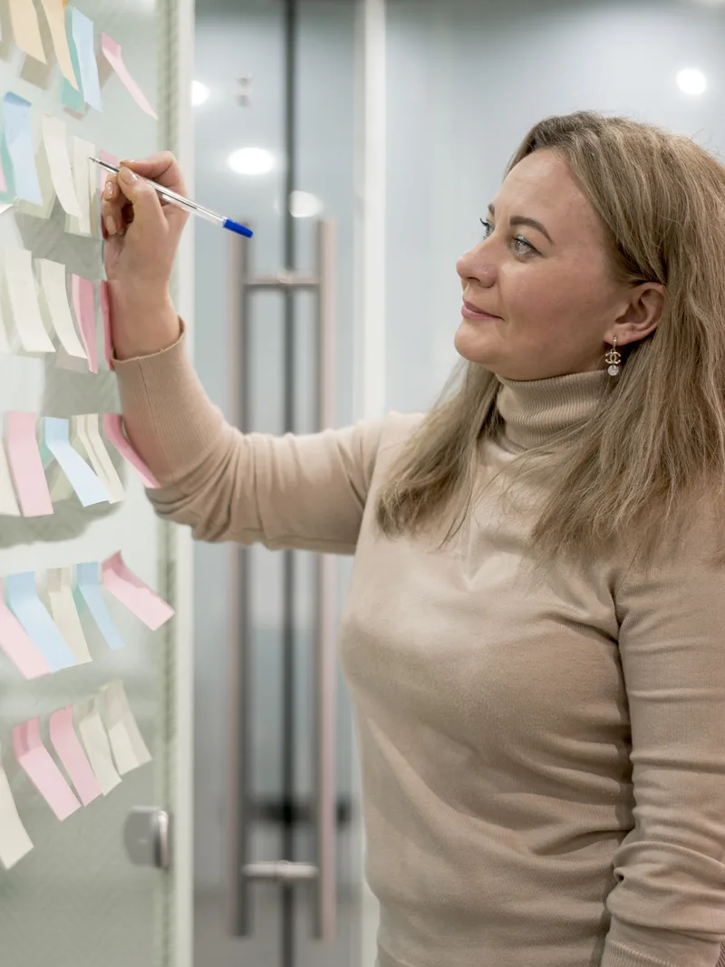 Consultant mapping a plan on a sticky-note wall