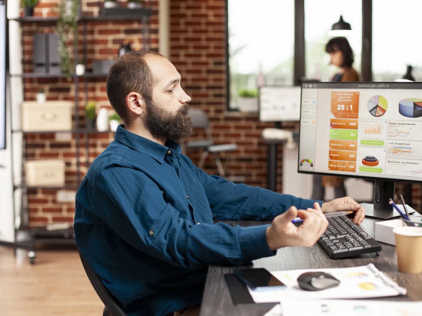 Analyst reviewing KPI dashboards on monitors