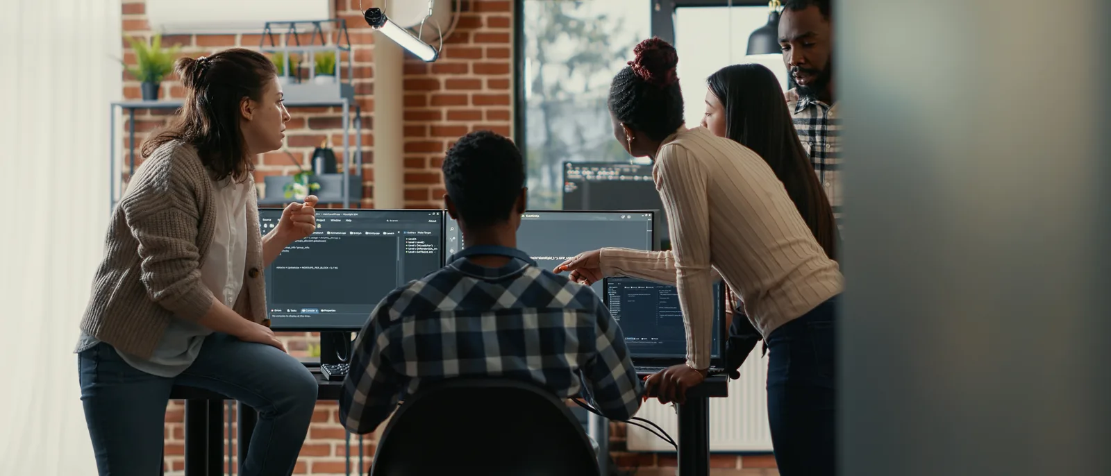 Developers discussing code around a desk