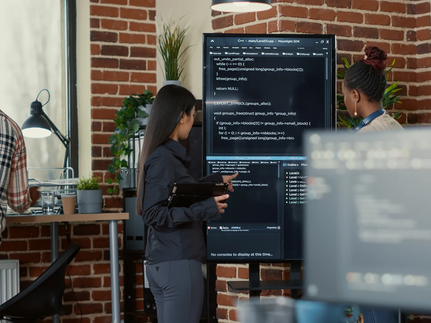 Engineers reviewing pipeline code on wall screen