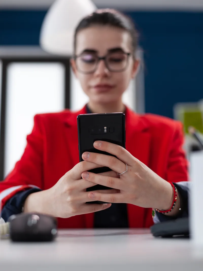 Woman checking a mobile app at her desk
