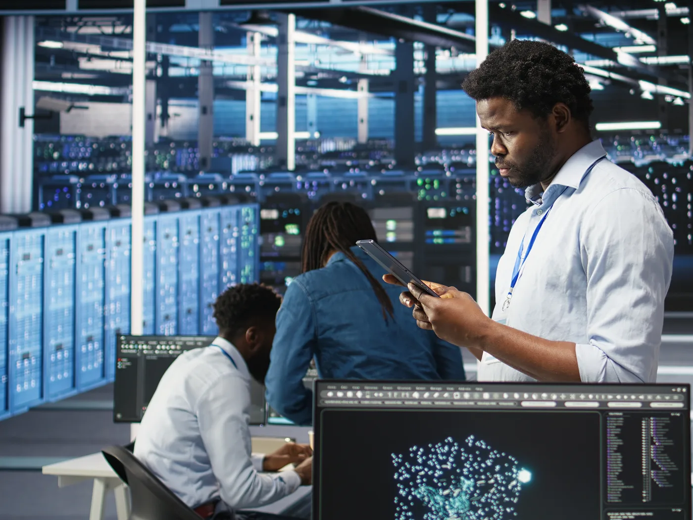 Engineers working with tablets in a server room