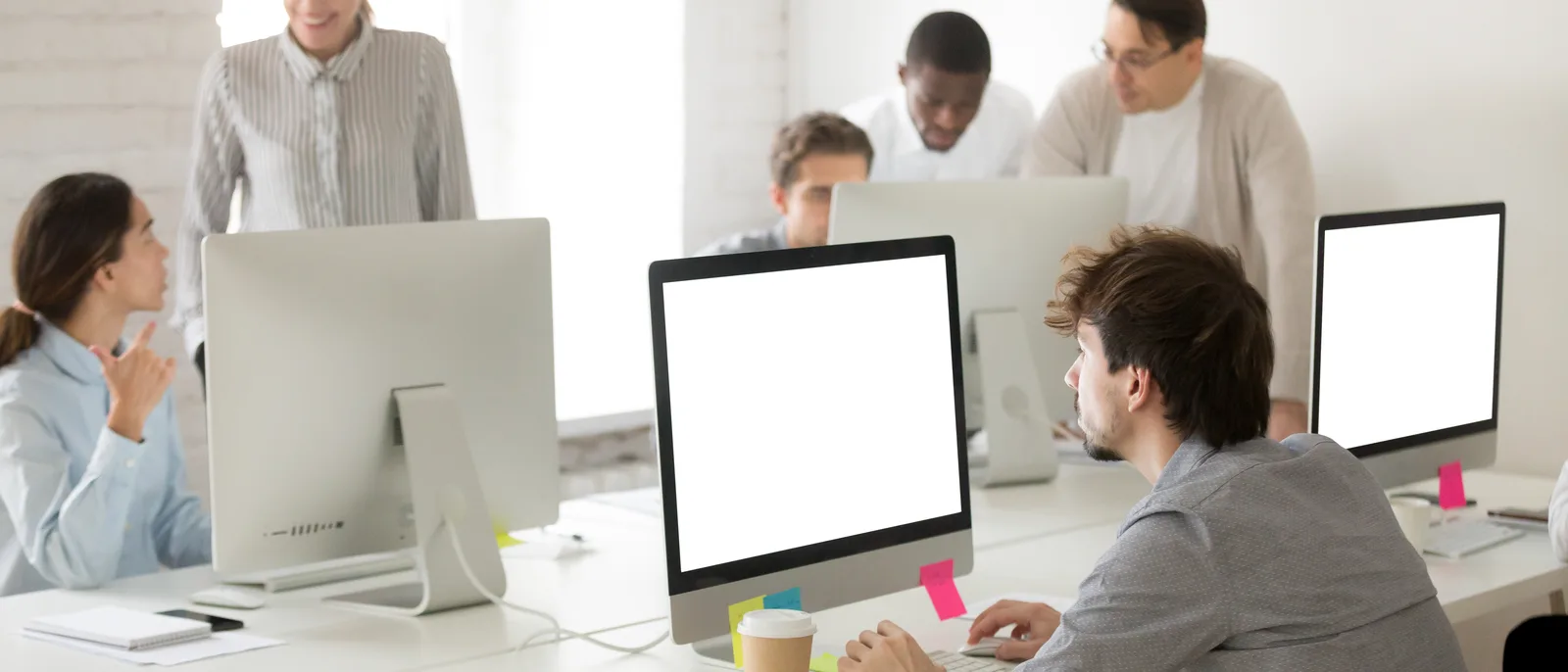 Diverse team working at computers in bright office