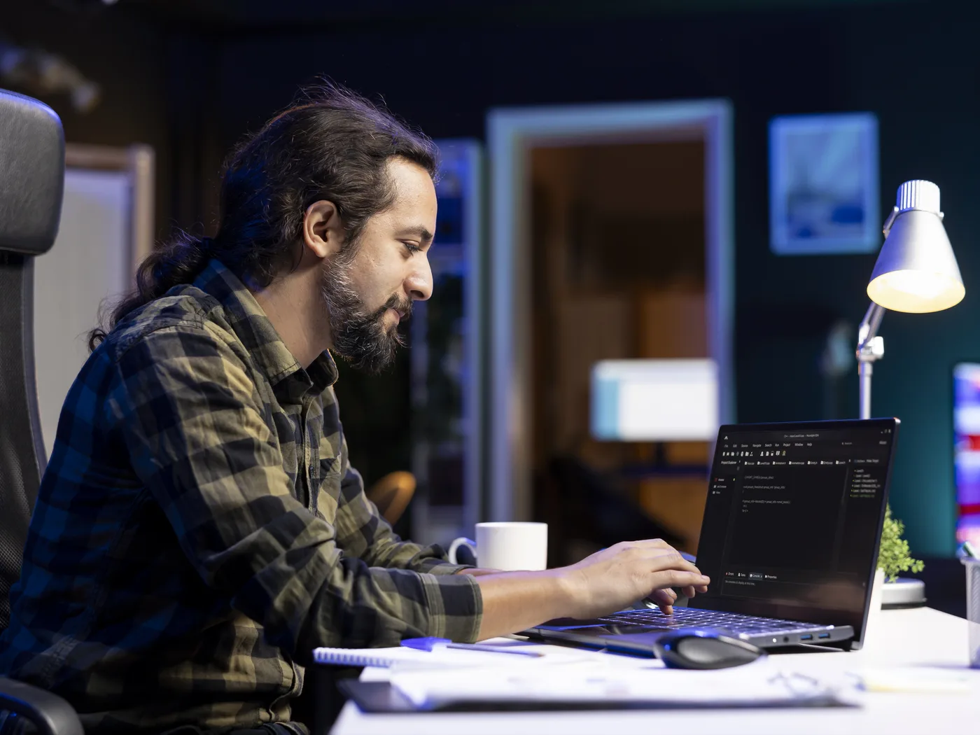 Developer coding on laptop at night