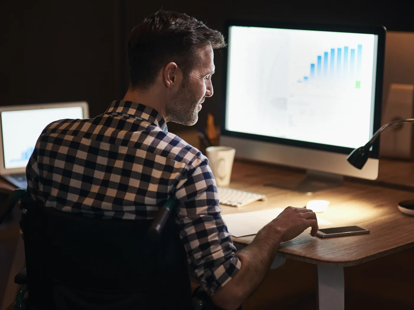 Man reviewing rising trend chart on monitor