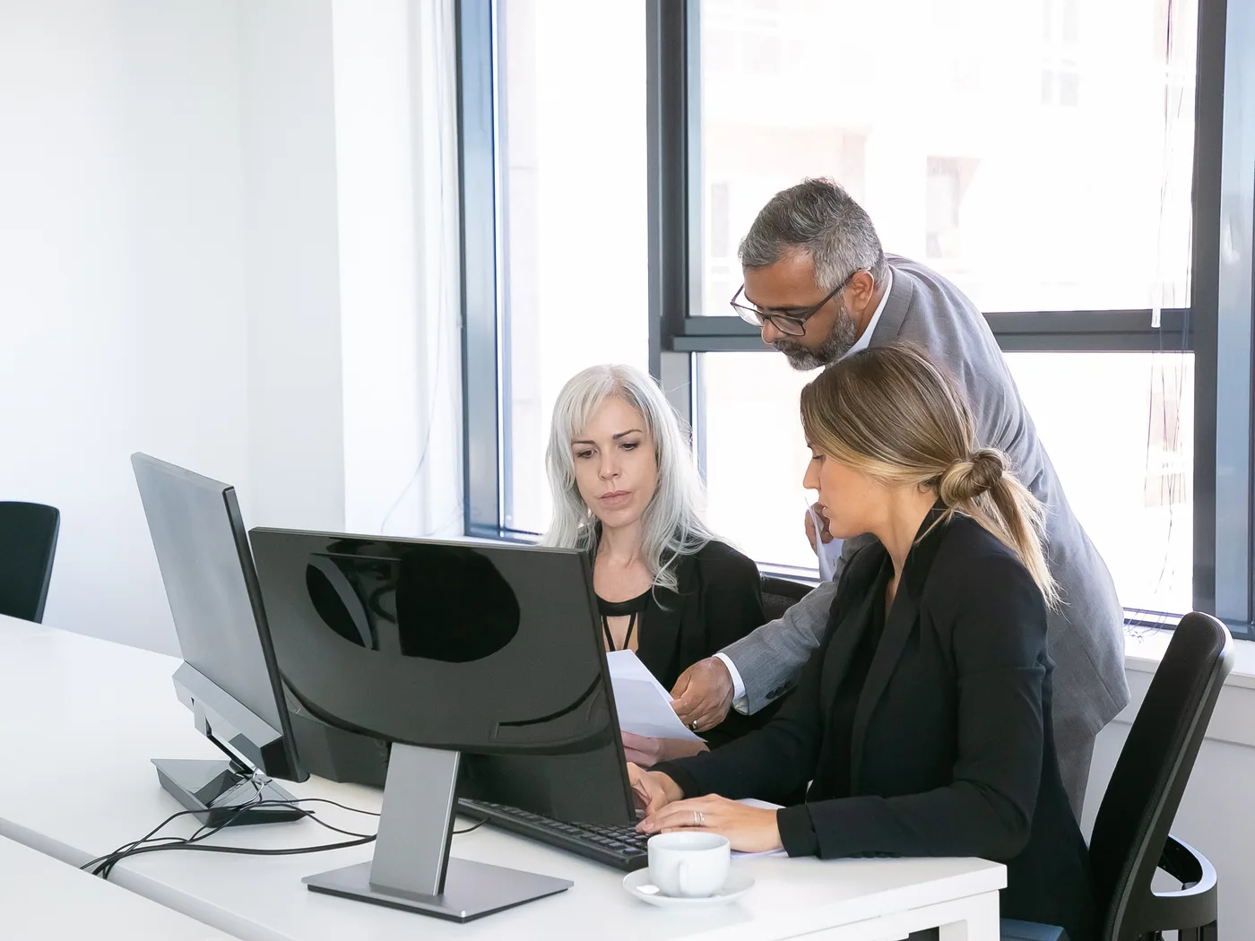 Team reviewing reports together at office workstation