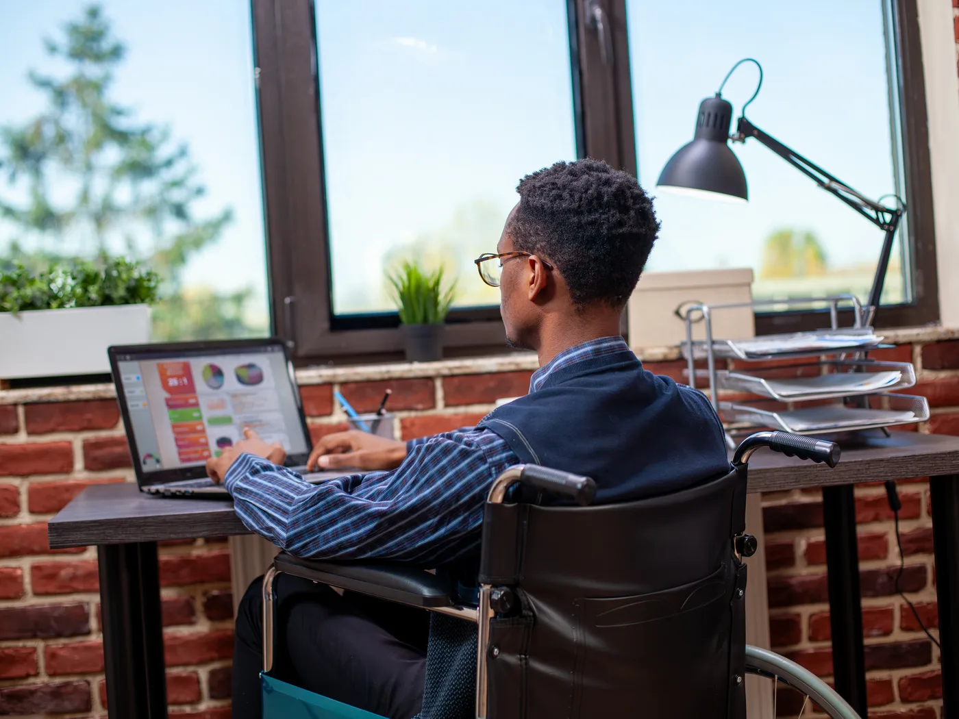 Wheelchair user working on a laptop in the office