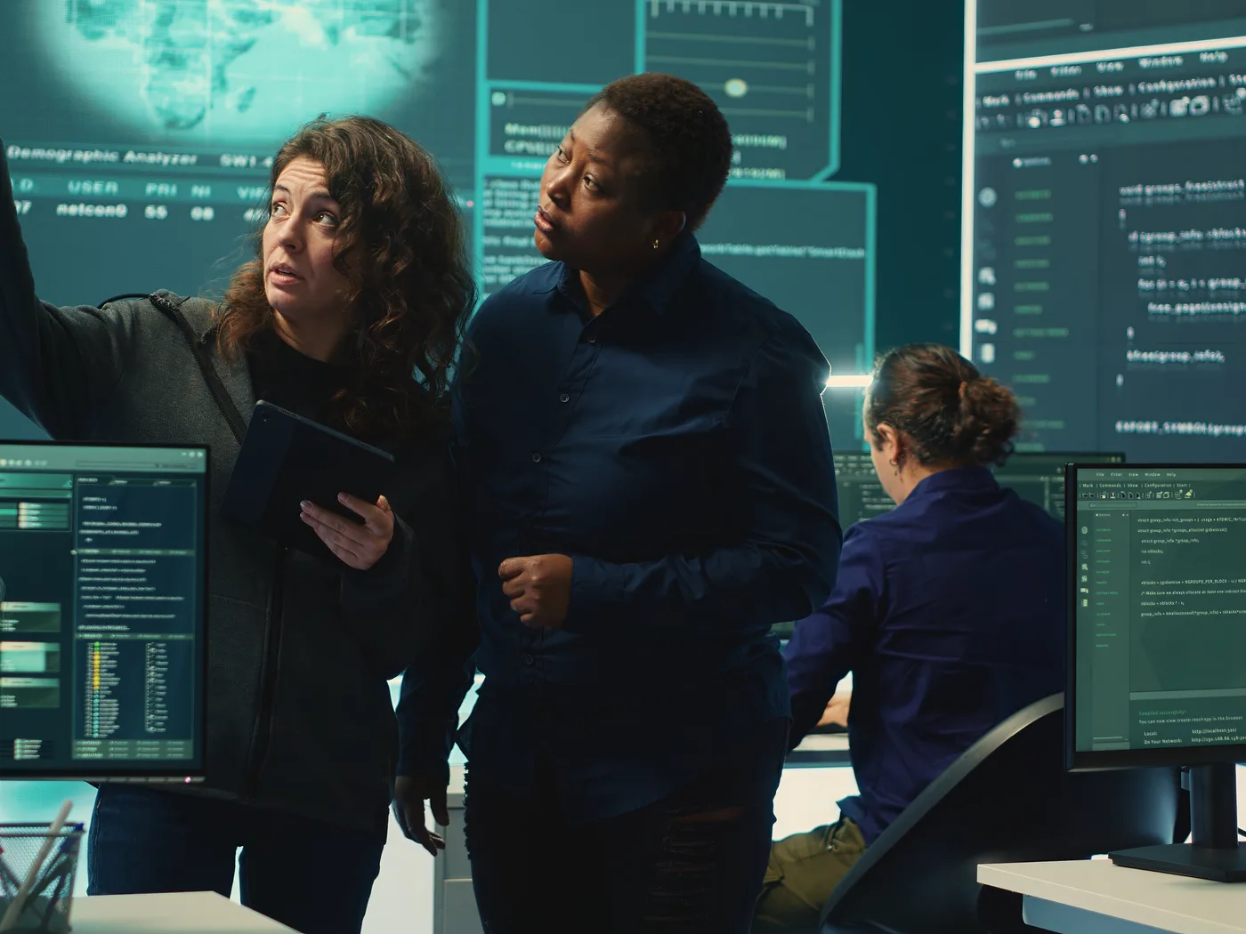 Security specialists reviewing threats on screens together