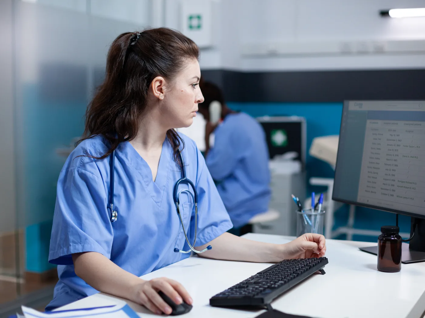 Nurse checking patient records on a clinic computer